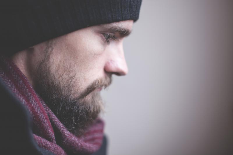 Bearded man with hat and scarf looking off camera